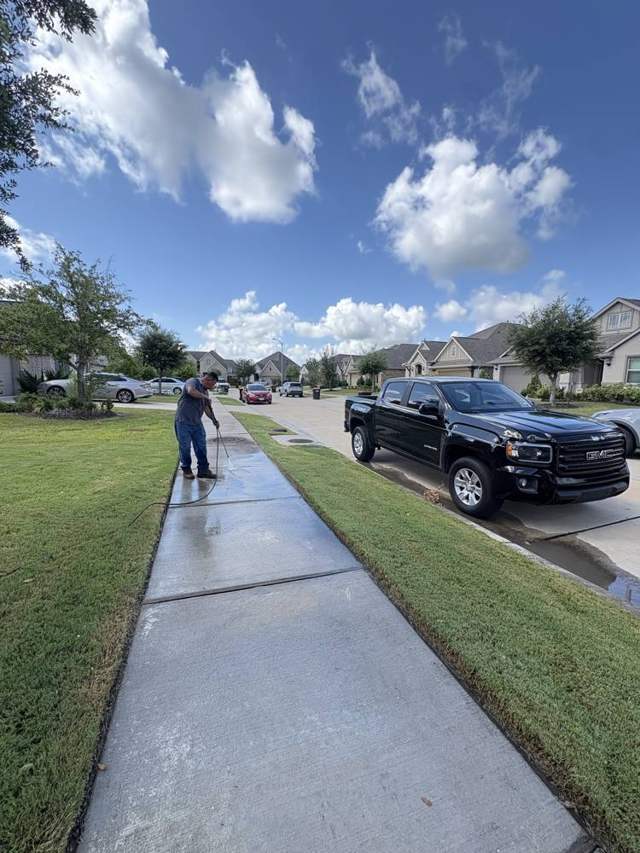 Crew pressure washing a sidewalk